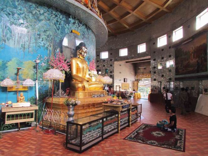 A woman praying at one of the four Buddha statues inside
